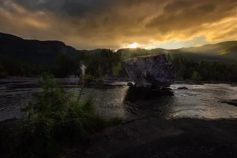 Road trip rest stop Large Boulder in  Otra river Scandinavian landscape at su Stock Photos