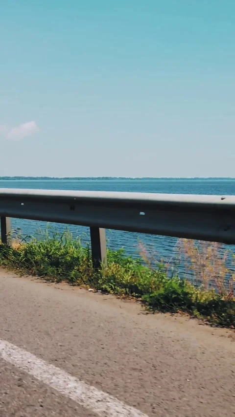 Road trip. view from Driving Car. Car speeding on a road along river or lake. Stock Footage 310951724