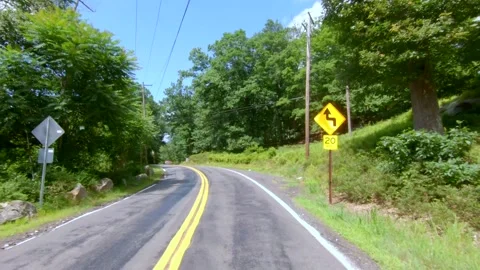 Road trip winding small road in forest with tree shadows on the asphalt - NY Stock Footage 135670645