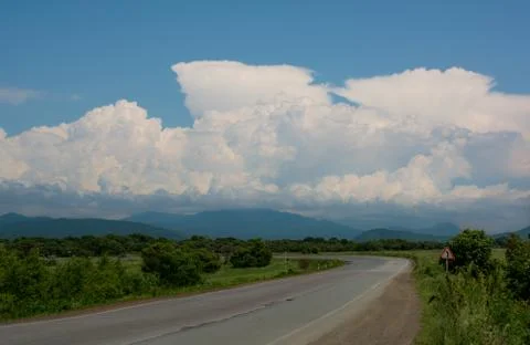 Road turn to the left, cloudy sky nature, the sign turn to the left! Stock Photos