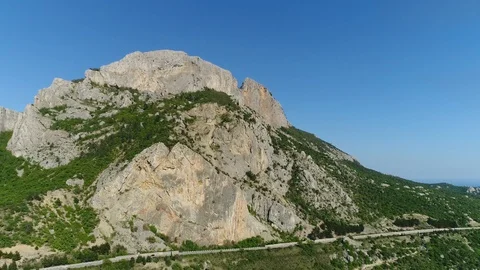 Road under the Cliff of The mountain Range. Flying over a Mountain Road. Crimea. Stock Footage 125412378