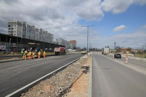 A road under construction with workers in protective vests Stock Photos