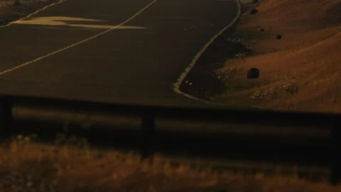 Road under sunset light with barren fields on the side Stock Footage 340608908