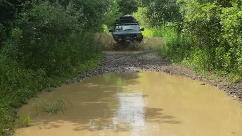 Off Road Vehicle coming fast through deep mud puddles toward a drone Stock Footage 259293166
