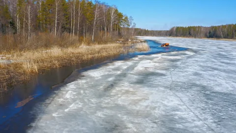 Off-road vehicle in dynamic action, jumping off an ice floe over a water barrier Stock Footage 262632659