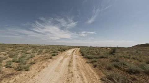 Off-road vehicle navigating dirt path through arid landscape under blue sky Stock Footage 341791031