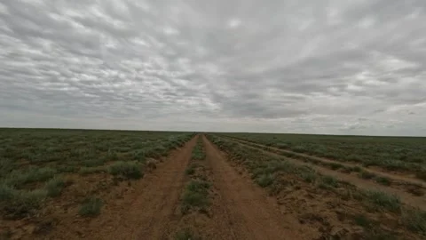 Off-road vehicle navigating dirt path through expansive grassland landscape Stock Footage 341791071