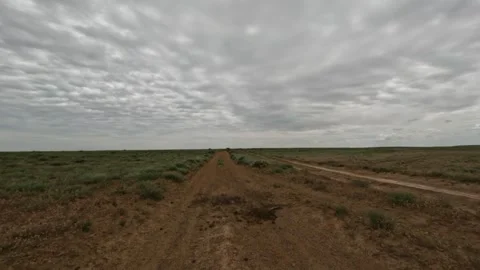 Off-road vehicle navigating dirt path through open landscape under cloudy sky Stock Footage 342502417