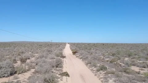Off-road vehicle passing under the camera on a thin sandy track in semi-desert l Stock Footage 154650759
