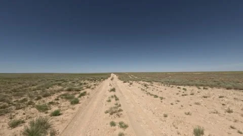 Off-road vehicle traverses sandy path through open grassland landscape Stock Footage 342503020