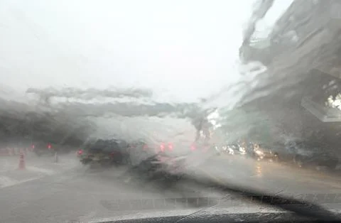 Road view through car window with Heavy rain and storm hits driving in rain Stock Photos