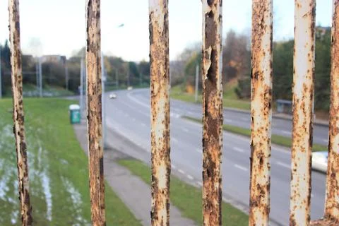 Road view through rusty grille 写真素材