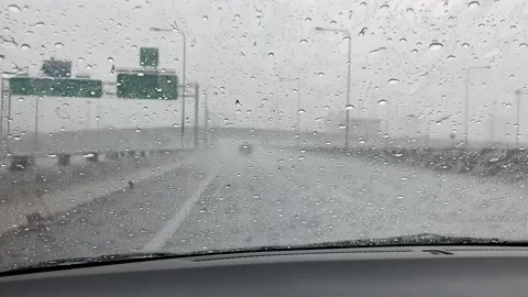 Road view traffic through car glass with heavy rain drops driving in raining Stock Footage 193876292
