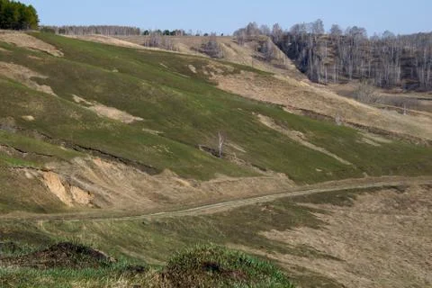 The road which is going down on a green slope, Siberia Stock Photos