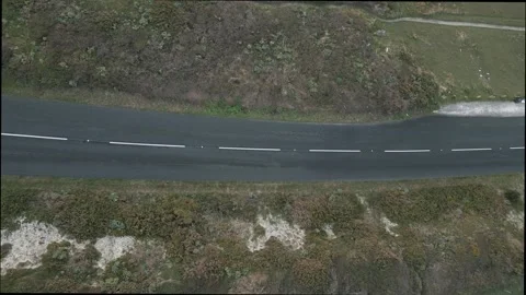 A road with a white line down the middle and a sign that says "SLOW" Stock Footage 298249458
