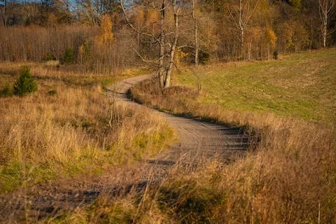 A road winding through fields and meadows. Part of the hiking trail Stock Photos