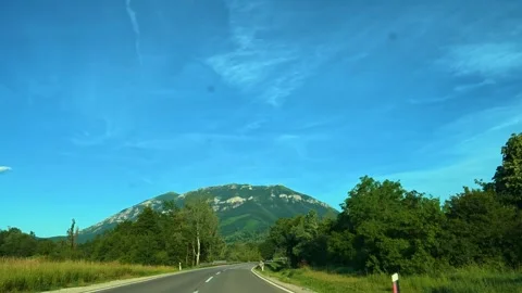 Road winds through green trees under clear blue sky. Mount Rtanj Area, Serbia Stock Footage 340898035