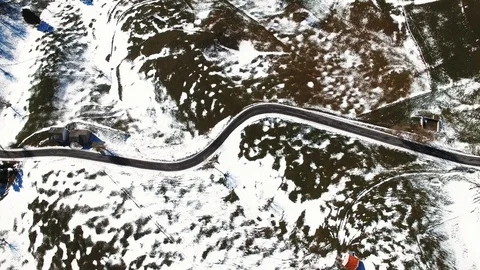 Road winds through the hills partially covered with snow. Stock Footage 92335818