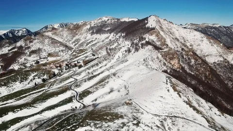 Road winds through the hills partially covered with snow. Stock Footage 92415874