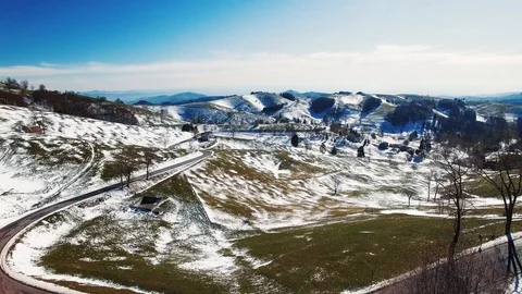 Road winds through the hills partially covered with snow. Stock Footage 93320976