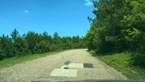 Road winds through lush green forest under bright blue sky. Balkans, Serbia Stock Footage 337487097