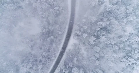 Road in the winter forest. Heavy snowfall. Aerial View. Siberian taiga. Video stock 81157457