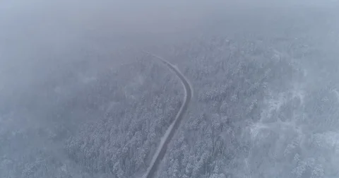 Road in the winter forest. Heavy snowfall. Aerial View. 스톡 동영상 81163650