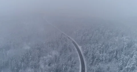 Road in the winter forest. Heavy snowfall. Aerial View. Siberian taiga. Stock Footage 81163671