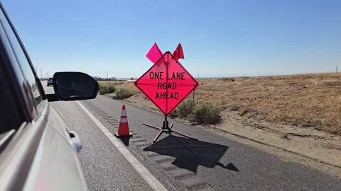 Road work ahead with one lane closure in a sunny landscape Stock Footage 296497403