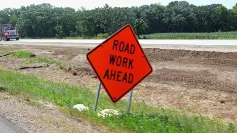Road Work Ahead sign at a construction with approaching truck. Stock Footage 202146923
