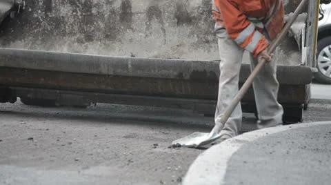 Road worker cleaning pavement with shovel Stock Footage 24821809