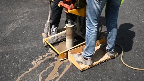 Road worker drilling asphalt core sample for pavement quality inspection Stock Footage 339092198