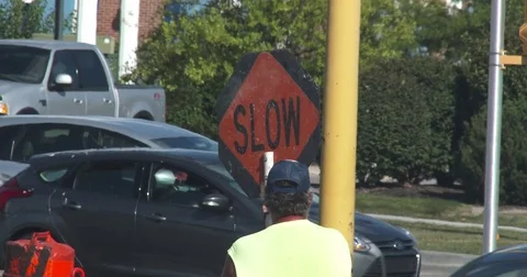 Road Worker Holding a SLOW sign Stock Footage 78556061