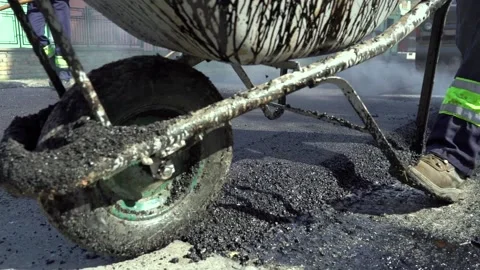 Road Worker Pushing a Wheelbarrow Over Hot Tarmac in Slow Motion Stock Footage 237613597