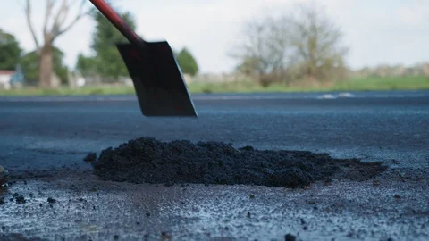 Road worker repairing a large pothole on a busy highway. Stock Footage 93104506