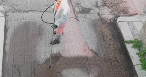 Road worker spraying bitumen emulsion with the hand spray lance before applyi Video stock 194027924