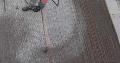 Road worker spraying bitumen emulsion with the hand spray lance before applyi Video stock 194028271