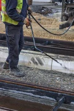 Road worker spraying manually bitumen emulsion Stock Photos