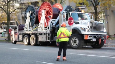 Road worker with stop sign regulating traffic Stock Footage 57787163
