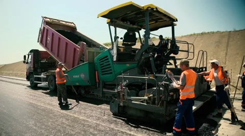 Road Workers are laying New Asphalt on the Road Construction Stock Footage 64908569