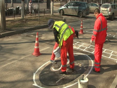 Road workers paint a road sign Stock Footage