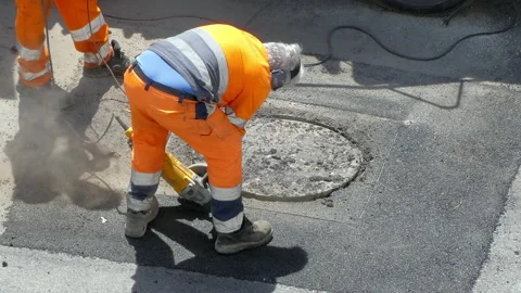 Road workers in protective uniform breaking cement sidewalk with electric manual Stock-Footage 139301044