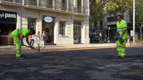 Road workers remove asphalt from the roadway with jackhammers and pickaxe Stock Footage 118321456