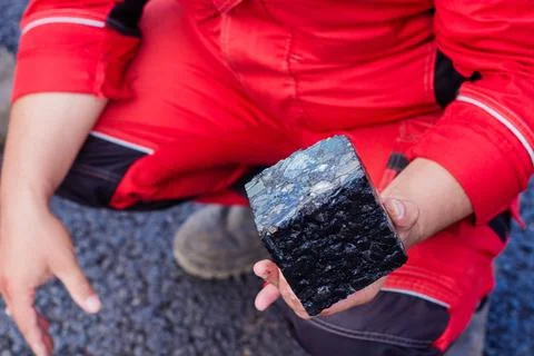 Road workers take a cube of asphalt Stock Photos