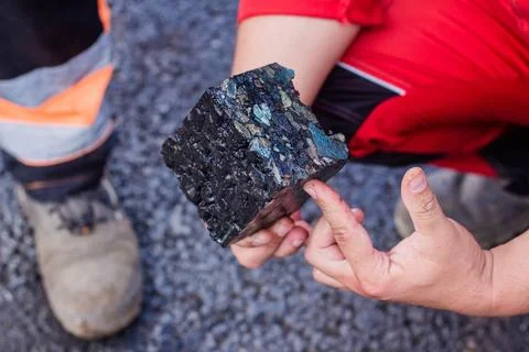 Road workers take a cube of asphalt Stock Photos