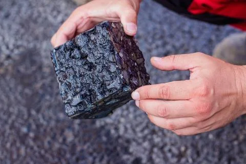 Road workers take a cube of asphalt Stock Photos