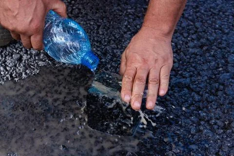 Road workers take a cube of asphalt Stock Photos