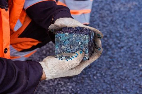 Road workers take a cube of asphalt Stock Photos