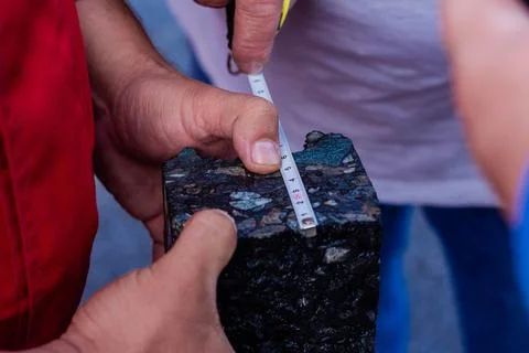 Road workers take a cube of asphalt Stock Photos