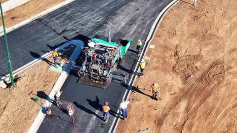Road workers tamping down hot bitumen after paving machine Stock Footage 279357229